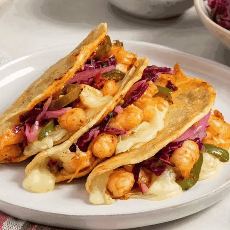 Three crispy tacos filled with shrimp, melted cheese, pickled red onions, and green peppers.