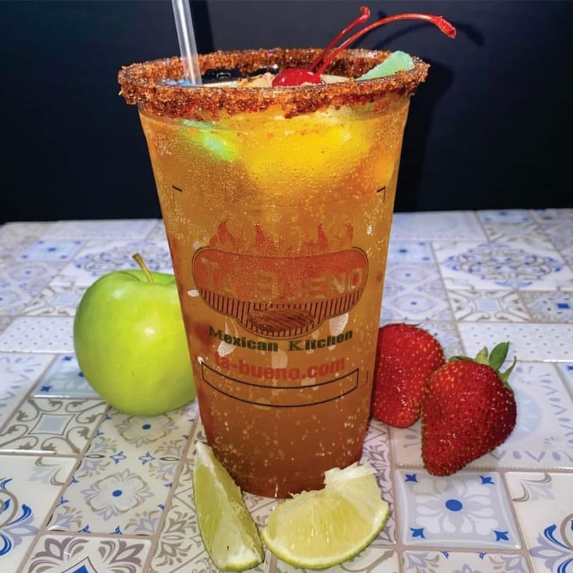 A large drink from "Ta Bueno Mexican Kitchen" with a chili-lime rim, cherries, and gummy bears.